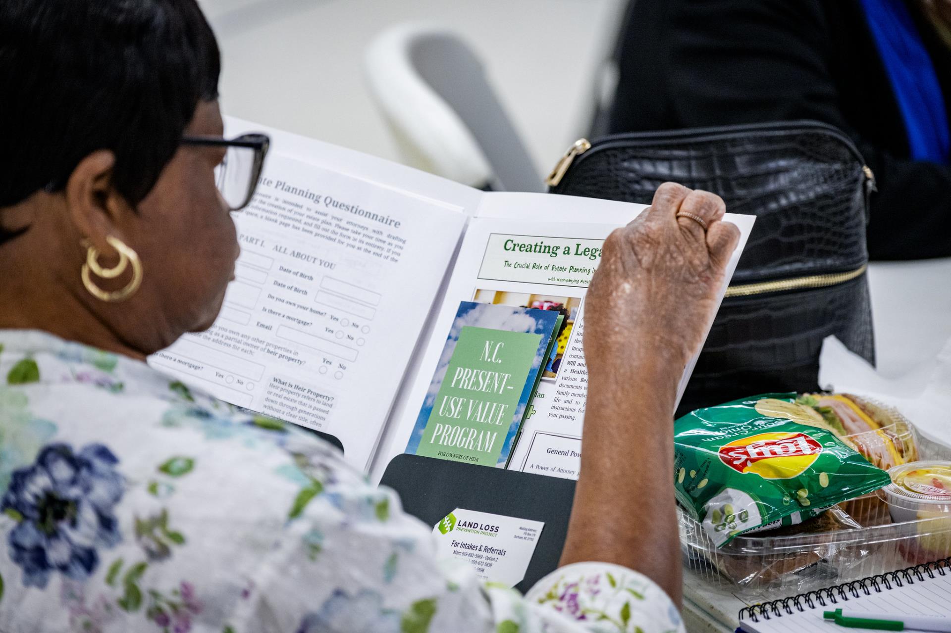 photo from behind a lady looking at a packet of information