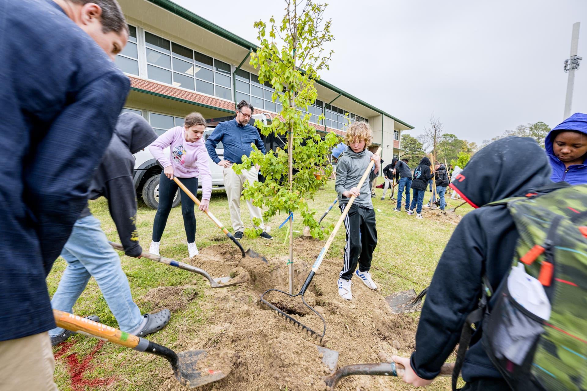 The mayor and children planting trees at C.M. Eppes Middle School.